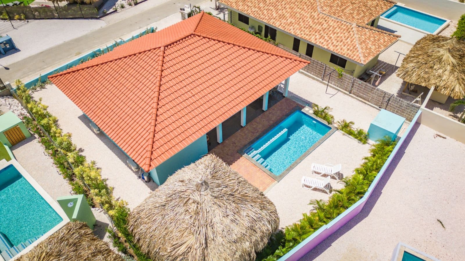 Bovenaanzicht van de villa met dak, zwembad en palapa